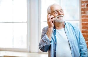 Smiling senior old man making a phone call
